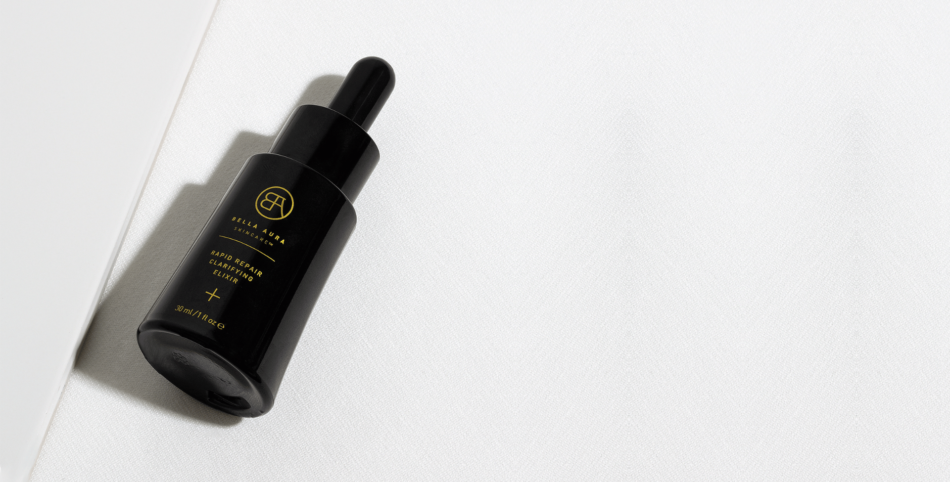 Bella aura skincare black dropper bottle rapid repair clarifying elixir with gold text and logo on a white background