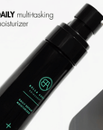 Black daily bella aura multi-tasking moisturizer bottle with green text on a white background