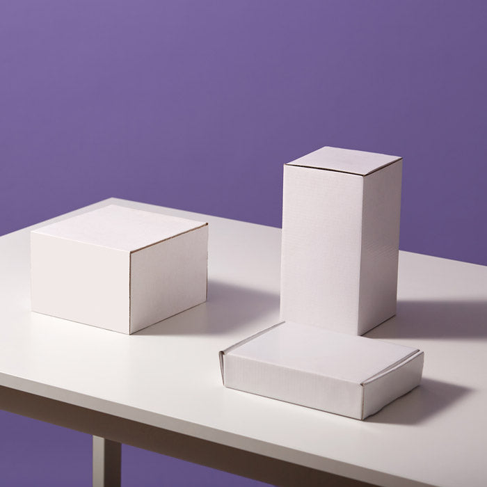 white boxes on a table on a purple background