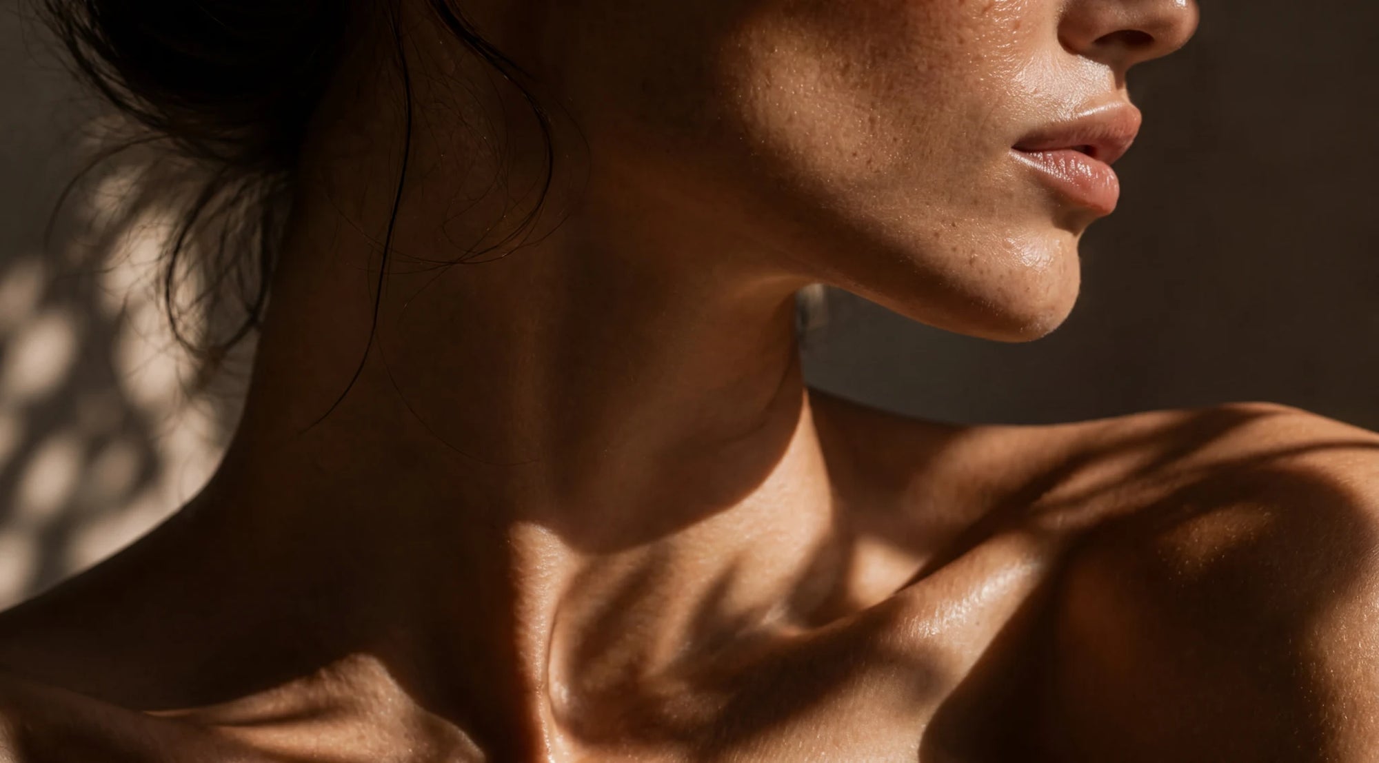Close-up of a person's neck and shoulders with a warm, brownish hue.