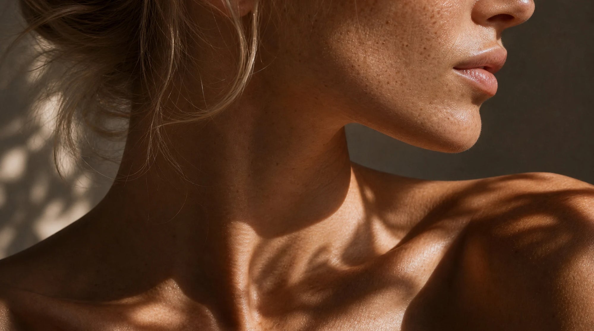 Close-up of a person's neck and shoulder with a soft focus background